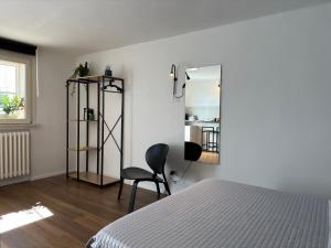 een slaapkamer met een bed, een stoel en een spiegel bij Residenza 1930 in Matera
