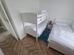 a bedroom with a bunk bed and a white bunk bed at The.deerparkcottage in Lurgan