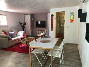 sala de estar con mesa blanca y sillas en Charmant appartement en rez de villa à Vence, en Vence