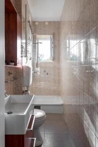 ein Badezimmer mit einem Waschbecken, einem WC und einer Badewanne in der Unterkunft Zagreb City Apartments in Zagreb