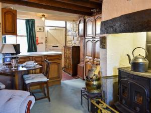 eine Küche mit einem Herd und einem Tisch im Zimmer in der Unterkunft Robsons Cottage in Alston