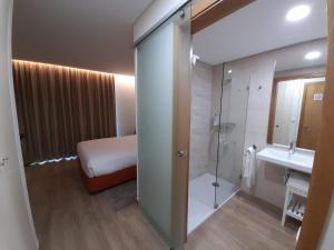 bagno con letto, doccia e lavandino di Casas da Serra - Soeima Housing a Alfândega da Fé