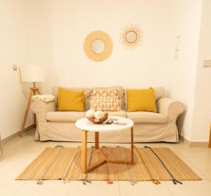 un soggiorno con divano e tavolo di GoToSeville ALTAIR SUITES a Siviglia