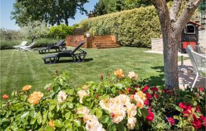 a yard with two chairs and flowers and a tree at 2 Bedroom Lovely Home In Massa Martana in Massa Martana