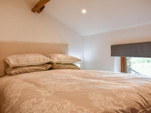 a bedroom with a bed with two pillows and a window at Scaley Beck - Uk39151 in Threlkeld