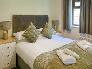 um quarto com uma cama com duas toalhas em The Hurlers em Saint Cleer