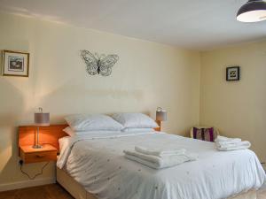 a bedroom with a bed with a butterfly on the wall at Southview Cottage in Cupar