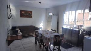 a kitchen and living room with a table and a couch at ACONCHEGO DE CANELA/RS in Canela