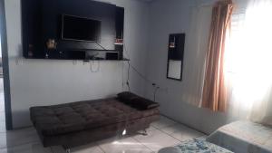 a living room with a couch and a flat screen tv at ACONCHEGO DE CANELA/RS in Canela