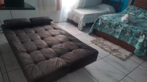 a brown leather couch sitting in a living room at ACONCHEGO DE CANELA/RS in Canela