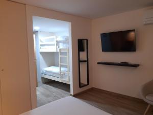 a room with a refrigerator and a tv on the wall at Casas da Serra - Soeima Housing in Alfândega da Fé