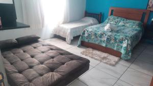 a room with two beds and a couch in it at ACONCHEGO DE CANELA/RS in Canela