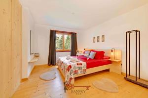 a bedroom with a red bed and a window at Chalet 5 stars in San Bernardino, SKI SLOPES AND HIKING, Fireplace, 4 Snowtubes Free, Wi-Fi Free, for 8 persons, Wonderful in all seasons -By EasyLife Swiss in San Bernardino