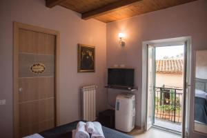 カプラローラにあるil Caravaggio b&bのベッドルーム1室(ベッド1台付)、バルコニーへのドアが備わります。