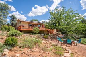 a house with a deck and chairs in the yard at Sedona Quail Hollow Retreat in Sedona