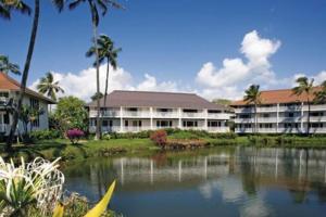 a resort with a lake in front of a building at Partial Oceanview 1BR at Kiahuna Plantation Unit 311 in Koloa
