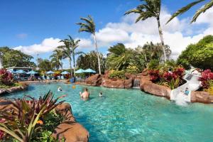 a group of people in a pool at a resort at Partial Oceanview 1BR at Kiahuna Plantation Unit 311 in Koloa
