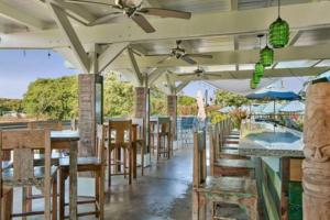 a restaurant with tables and chairs and a ceiling fan at Partial Oceanview 1BR at Kiahuna Plantation Unit 311 in Koloa