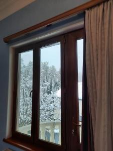 una ventana con vistas a un patio cubierto de nieve en Hotel Good Luck en Kutaisi