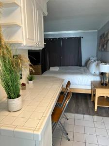 a room with a bed and a kitchen with a table at Studio- Sleep 2,Pool, Parking,5min walk to Beach -3 in Fort Lauderdale