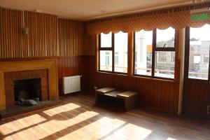 un salon avec une cheminée et une fenêtre dans l'établissement Hostal Ochen, à Punta Arenas
