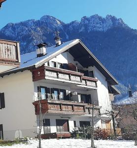 un grande edificio bianco con montagne sullo sfondo di La Mansarda di Sabina. a Fiera di Primiero