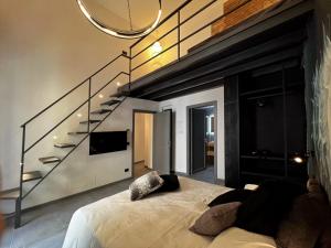 a bedroom with a bed and a tv and stairs at Sant'Andrea - Luxury Rooms in Vucciria in Palermo