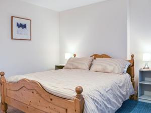 a bedroom with a large wooden bed with striped pillows at Ring Of Bells in South Molton