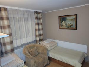 um pequeno quarto com uma cadeira e uma cama em Dom gościnny Monika em Pobierowo