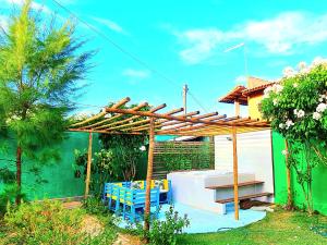 pérgola de madera con mesa y sillas debajo en Di Pipa Rooms - Hidromassagem Externa, en Pipa