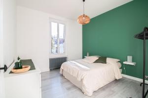 a bedroom with a bed and a blue wall at ✦ Maison avec jardin - Plaza Verde✦ in Commentry