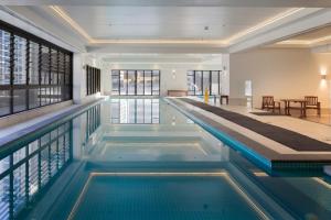 a swimming pool with blue water in a building at Luxury Penthouse Apartment in Auckland