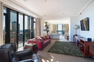 uma sala de estar com um sofá e uma cadeira em Luxury Penthouse Apartment em Auckland