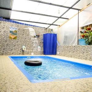 a swimming pool with a black tire in the water at Cabaña Vacacional Donde Ibañez in Fusagasuga