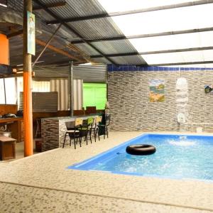 a swimming pool in a room with a table and chairs at Cabaña Vacacional Donde Ibañez in Fusagasuga