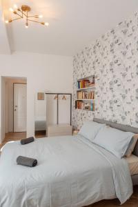 a white bedroom with a large bed and a wall at CASA Room Apartments Diaz 8 in Trieste