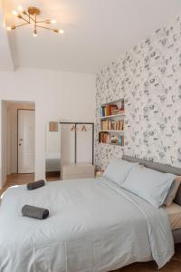 een witte slaapkamer met een groot bed en een muur bij CASA Room Apartments Diaz 8 in Trieste