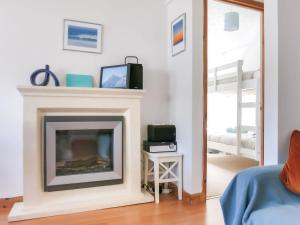 a living room with a fireplace and a mirror at The Chalet in Portreath