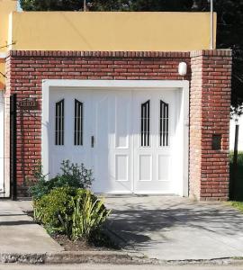 uma porta de garagem branca numa parede de tijolos em La casita de Punta Mogotes em Mar del Plata