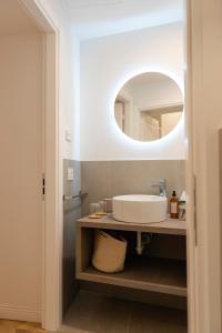 uma casa de banho com um lavatório e um espelho em CASA Room Apartments Diaz 8 em Trieste