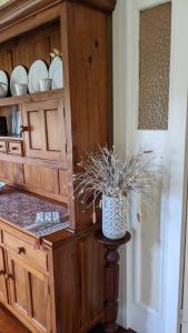 a wooden cabinet with a vase on a table at Amiens Cottage. Queenslander, charming, central. in Stanthorpe