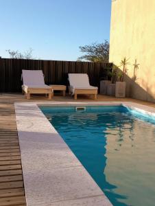 a swimming pool with two loungers next to a fence at Casa de Juan in Federación