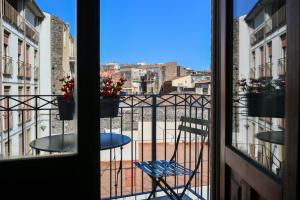 Habitación con vistas a un balcón con mesa y silla. en Dadà Suites, en Catania