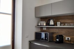 a microwave on a counter in a kitchen at Dadà Suites in Catania