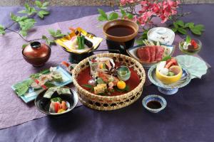 a table topped with bowls of food on a purple table at Mutsumikan in Gero