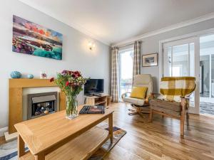 a living room with a table and a fireplace at Holly Cottage in Culbokie