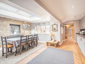 cocina y comedor con mesa y sillas en Cherrytree Cottage, en Chatton