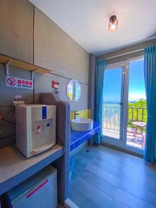 uma casa de banho com um lavatório e uma grande janela em Kenting Bayview Hotel em Nanwan
