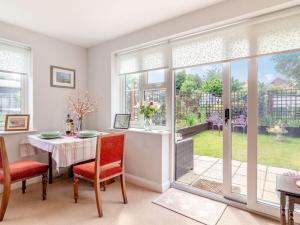 a dining room with a table and chairs and windows at Stellas Retreat in Loddon