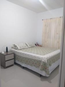 een slaapkamer met een bed en een nachtkastje bij Casa Cibratel 2 in Itanhaém